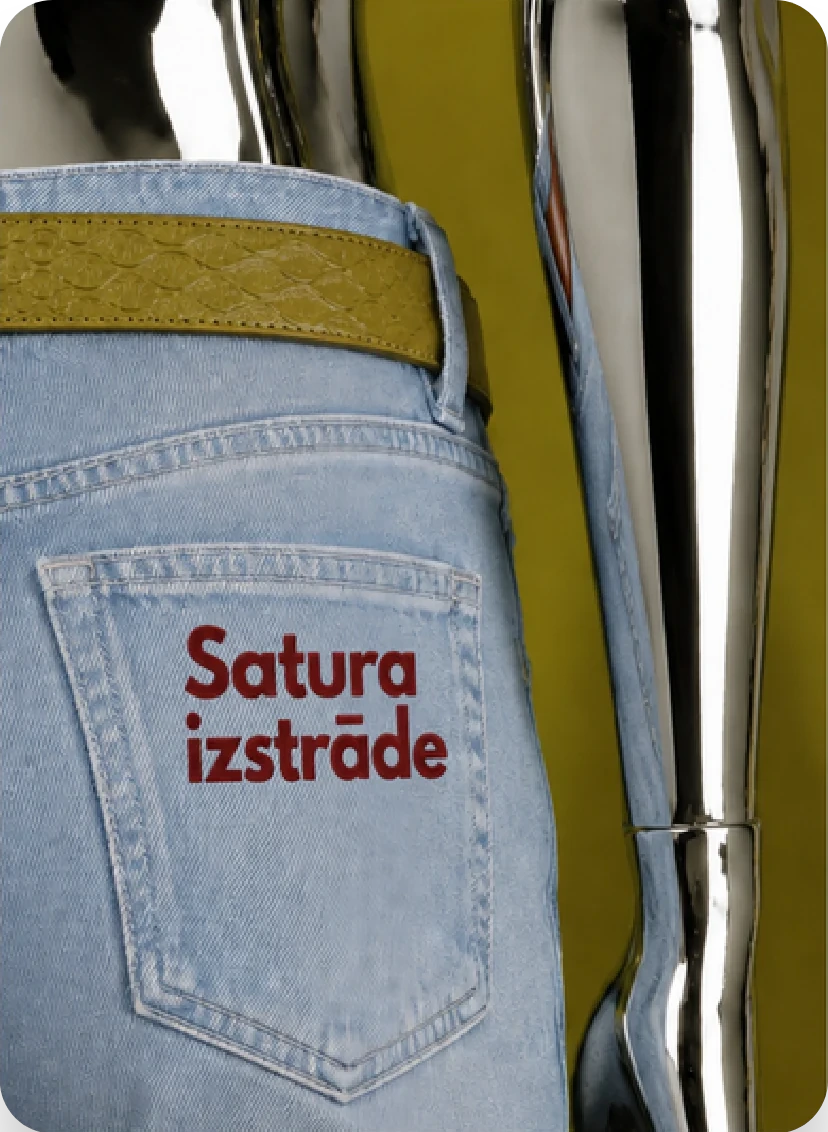 Džinsu kabata ar uzrakstu “Satura izstrāde” blakus hromētai rokai